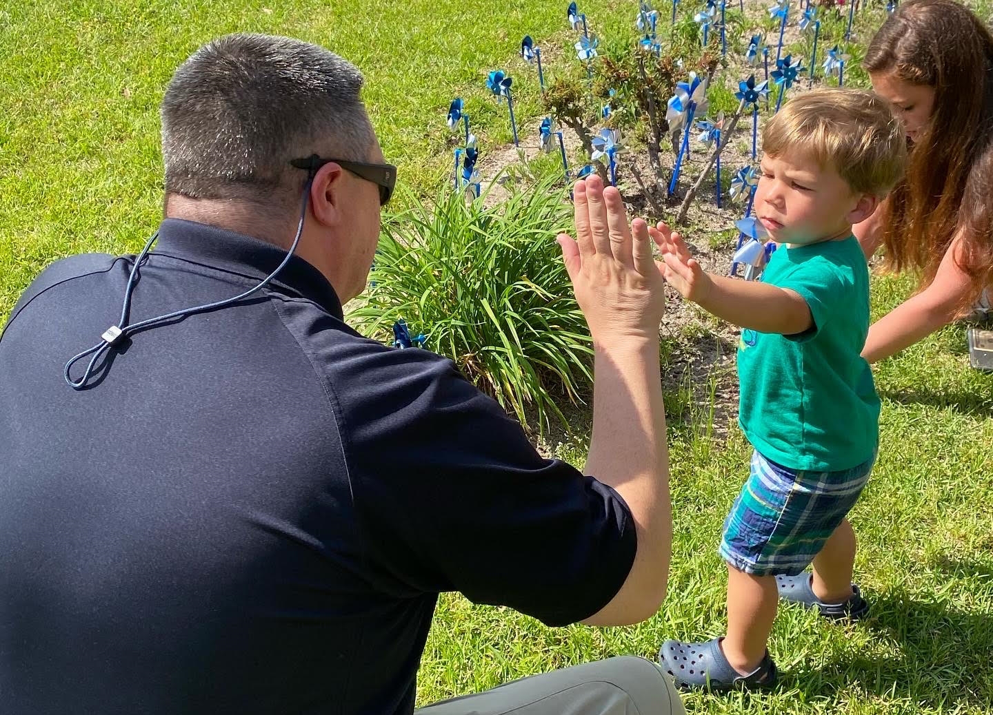 sheriff's department officer high fiving young boy