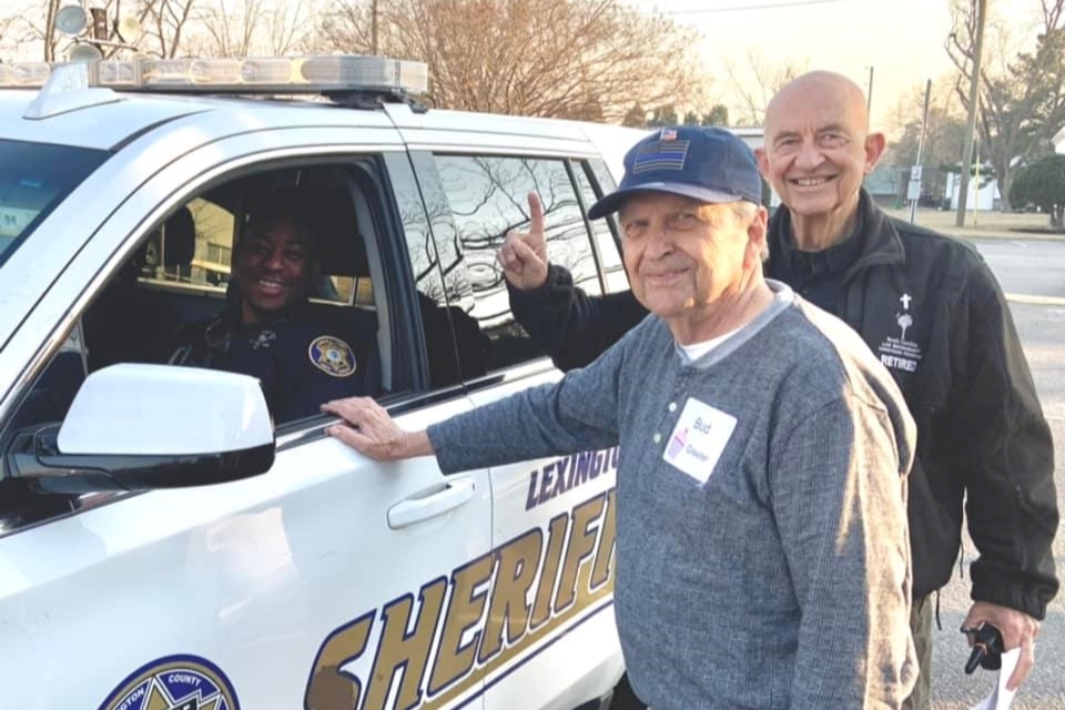 volunteers serve meal to deputy