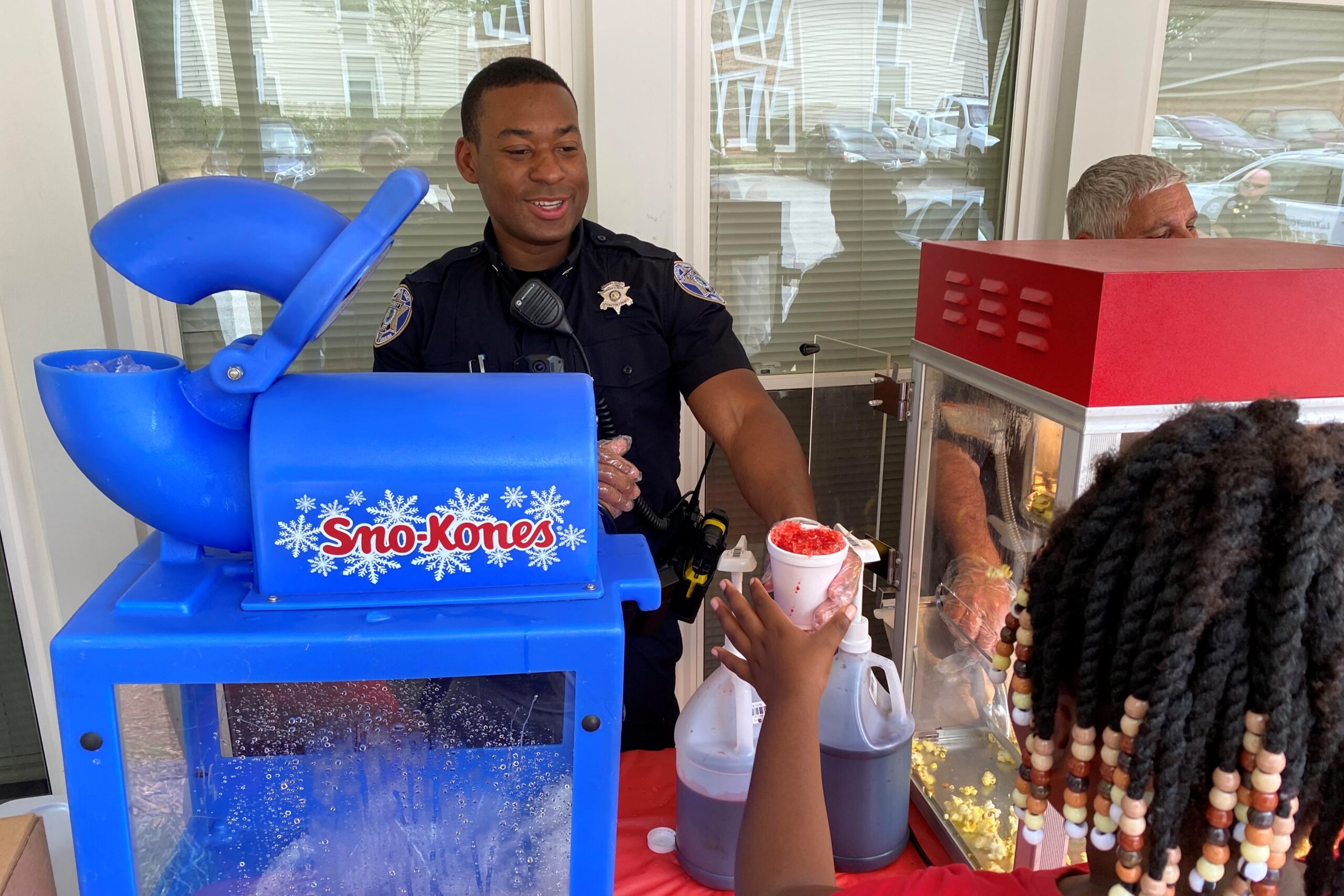 deputy serves sno cone to young girl